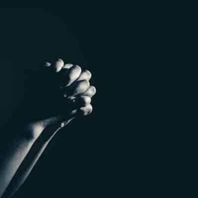 Ten Prayers for Public Schools | The Navigators Prayer Resource | clasped hands praying against a black background
