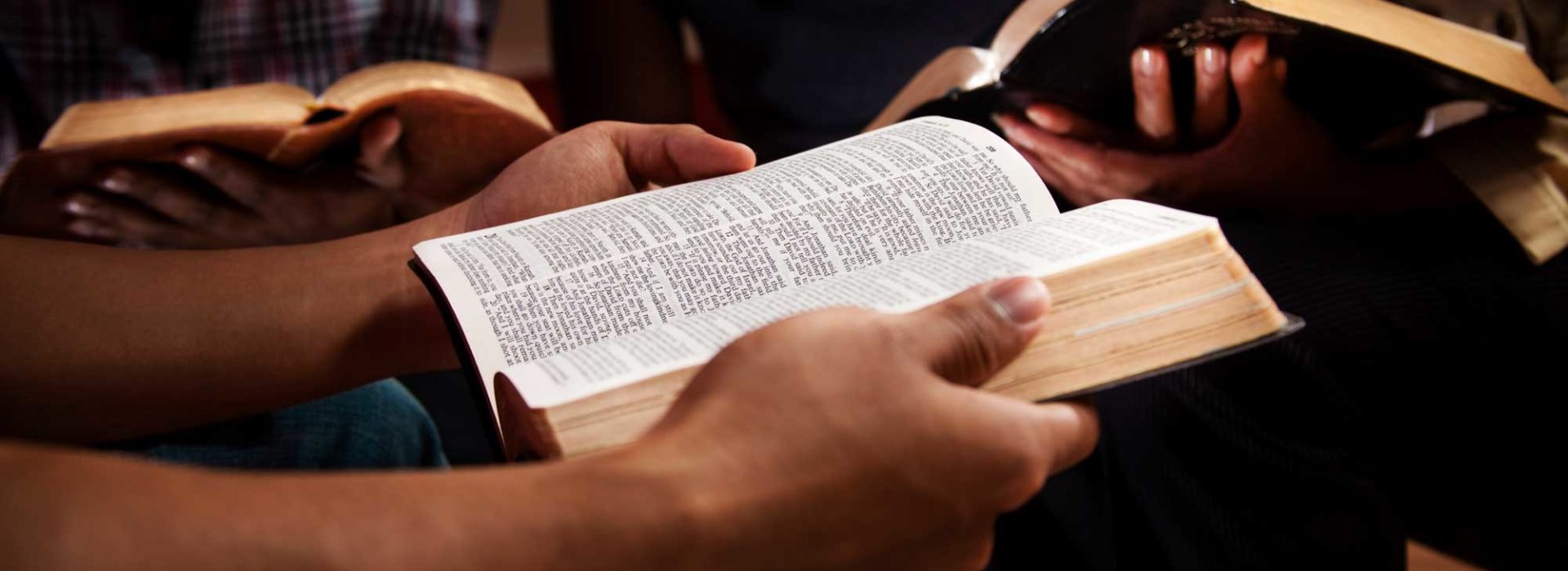 three people reading Bibles