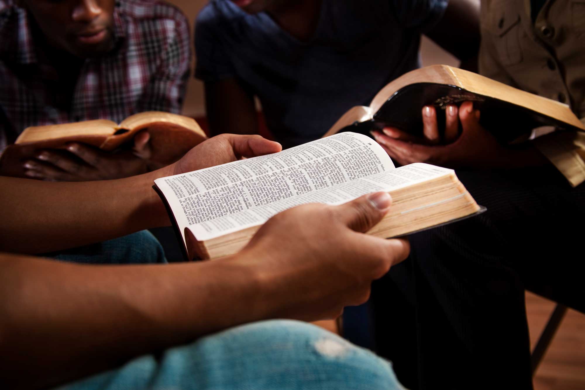 three people reading Bibles
