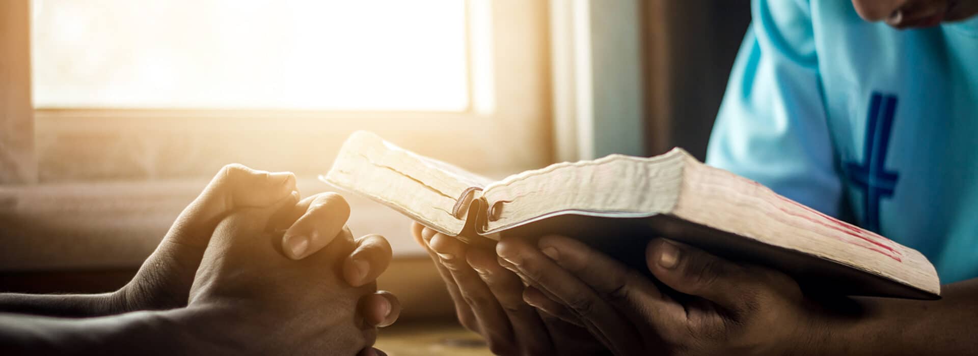 Praying the Names and Attributes of God | The Navigators Prayer Resource | Two young man praying and reading Bible at home