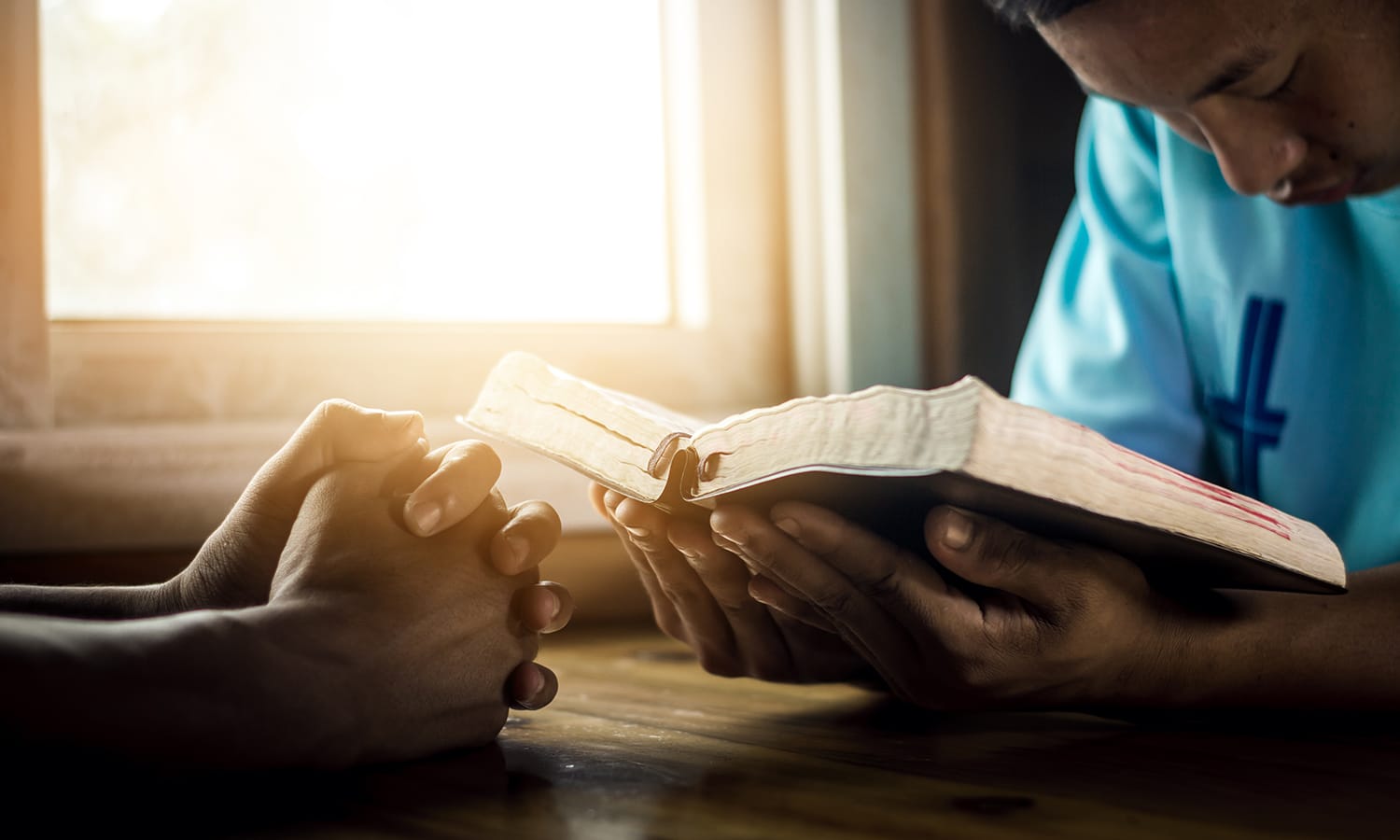 Praying the Names and Attributes of God | The Navigators Prayer Resource | Two young man praying and reading Bible at home