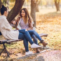 How to Prepare Your Personal Testimony | Navigators Discipleship Resource | Two female friends talking on a bench in autumn park
