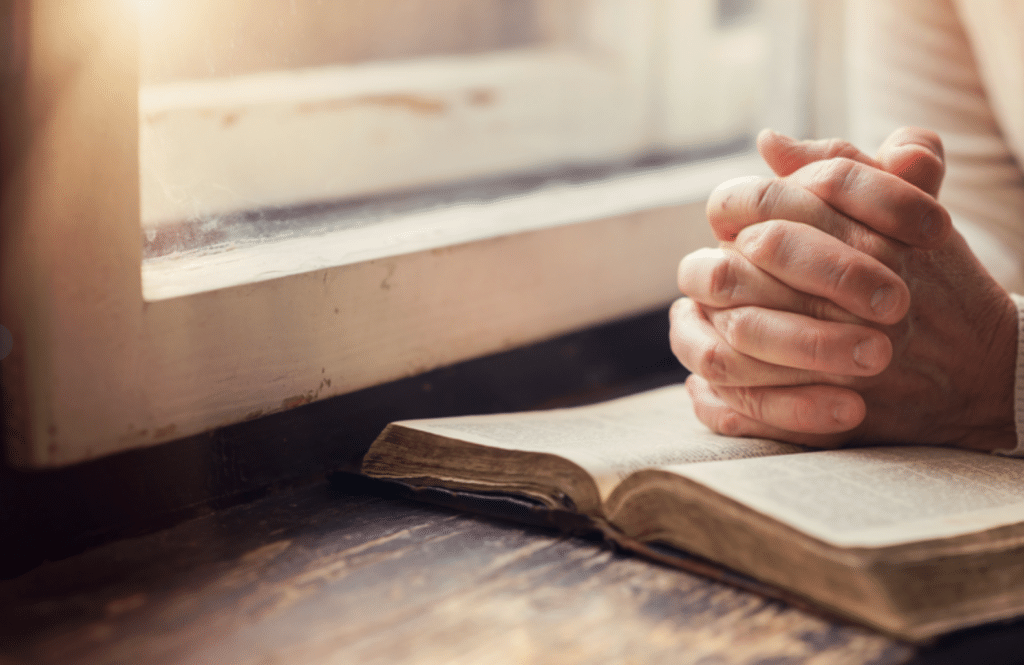 31 Days of Prayer | The Navigators Evangelism Resources | hands on a windowsill, clasped hands praying on an open bible
