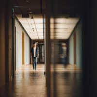 Holy Hallways | Student walking towards opened door in hallway