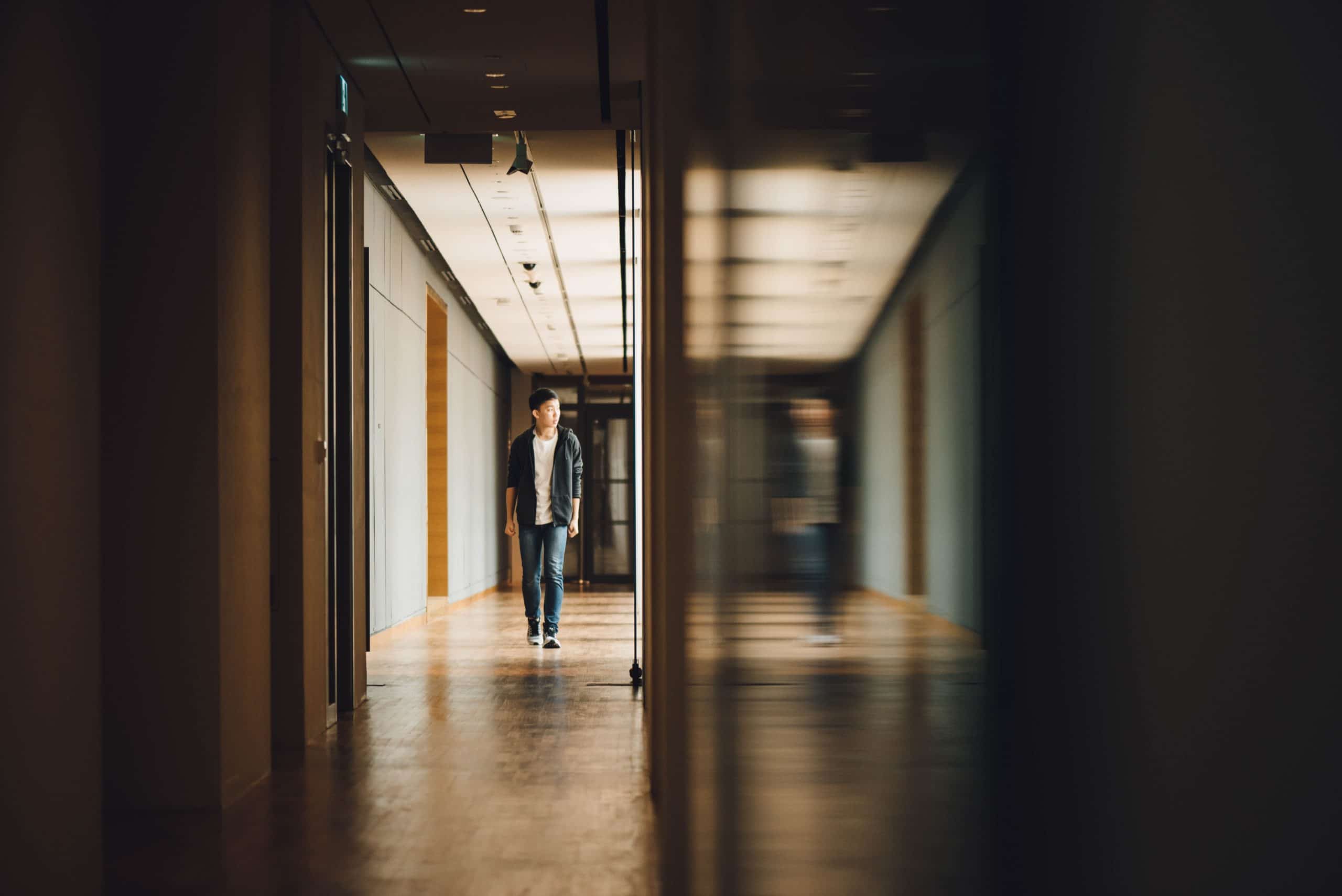 Holy Hallways | Student walking towards opened door in hallway