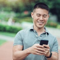 Luebe Brothers Podcast | The Navigators | Asian ethnicity man listening to his phone in the park