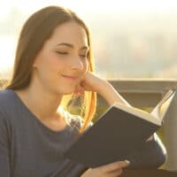Motivation for the Great Commission | The Navigators U.S. President Doug Nuenke with YouVersion Bible | Relaxed woman reading a hard cover book at sunset sitting on a park bench