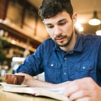 Young man working on the Navigators' Assurance of Salvation Bible Study at a local coffee shop