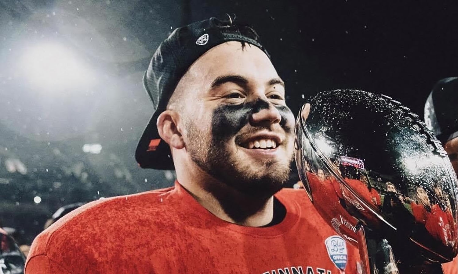 Faith and Football: Transformed Lives in College and Beyond | The Navigators Collegiate Ministry | Football player with a trophy