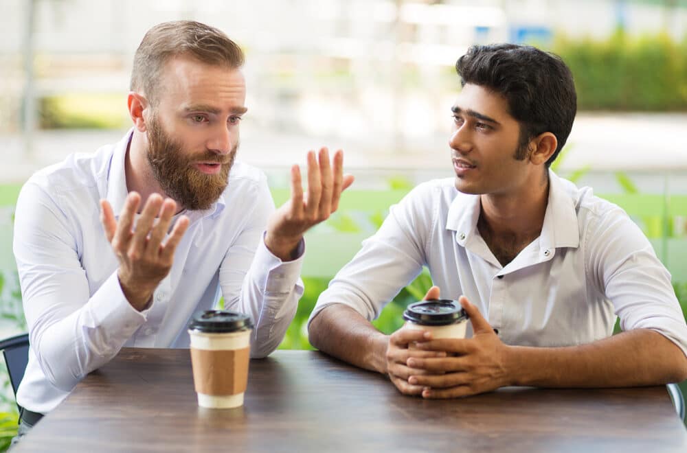 Help for Depression: How Do You Know if You're Drowning? | The Navigators Collegiate Ministry | Two male friends drinking coffee and talking in outdoor cafe