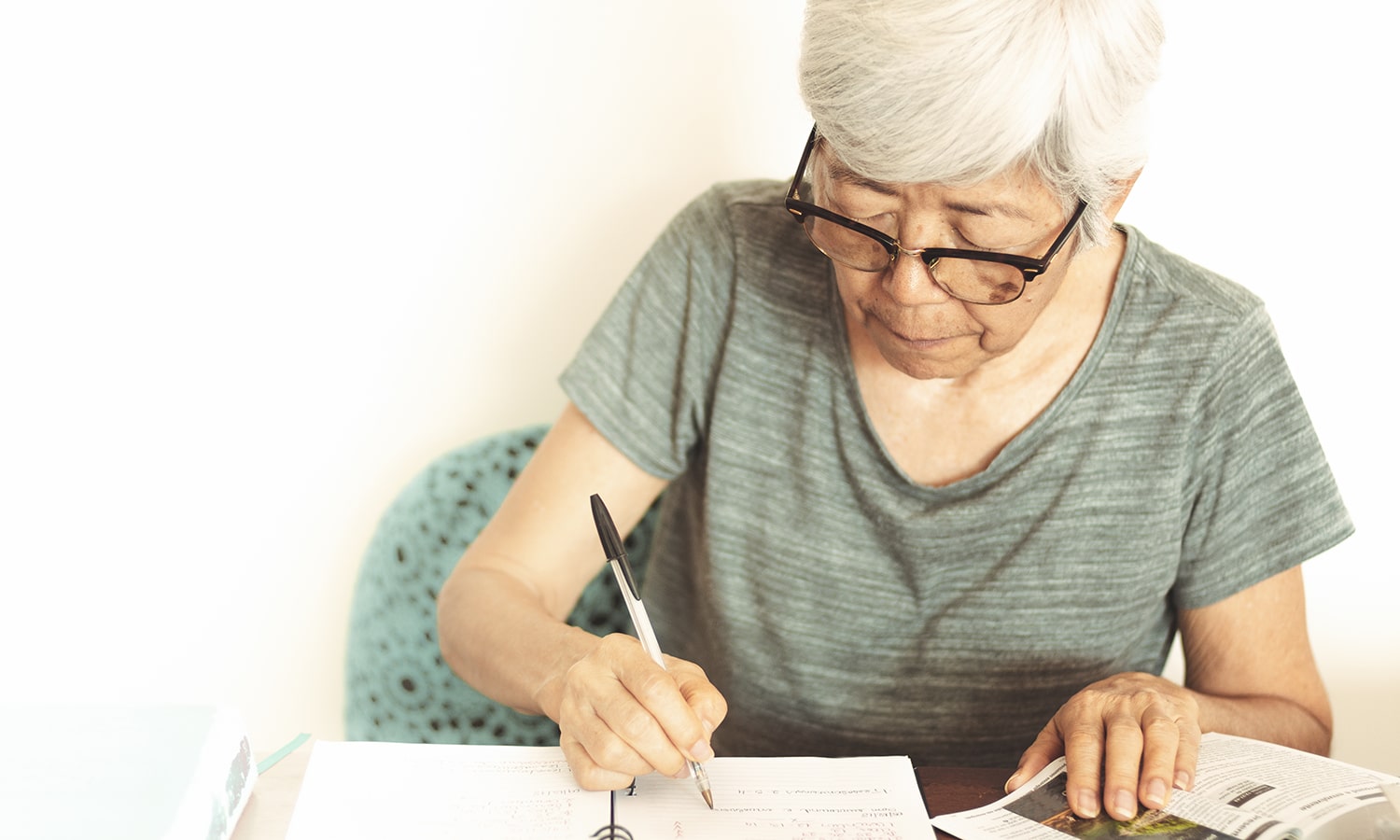 This Book Is for You: Loving God’s Words in Your Actual Life | Navigators Navpress Resource | Senior woman taking notes while reading a book at home.