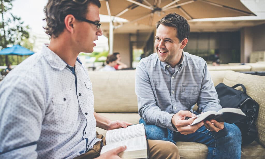 Two men sharing their prayer life and studying the Bible together.