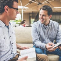 Two men sharing their prayer life and studying the Bible together.