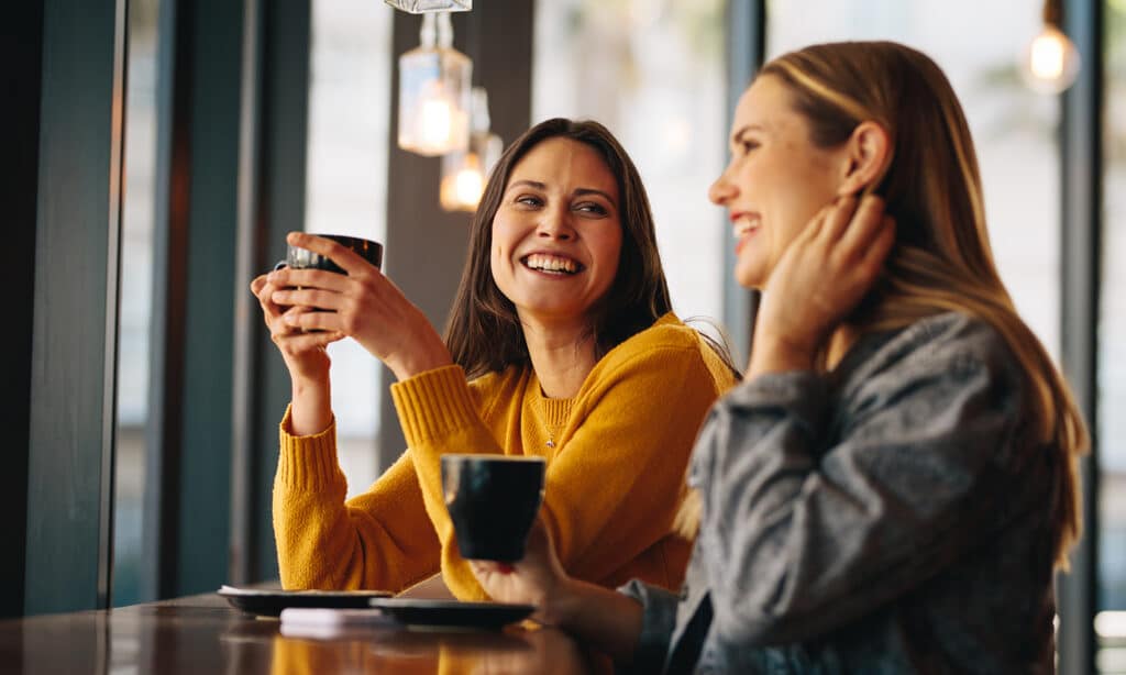 Two women meeting in a coffee shop while one shares their faith with another.