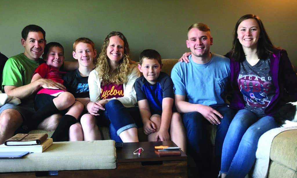 A family of Navigators gather together on a couch, showing the impact of generational discipleship.