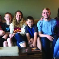 A family of Navigators gather together on a couch, showing the impact of generational discipleship.