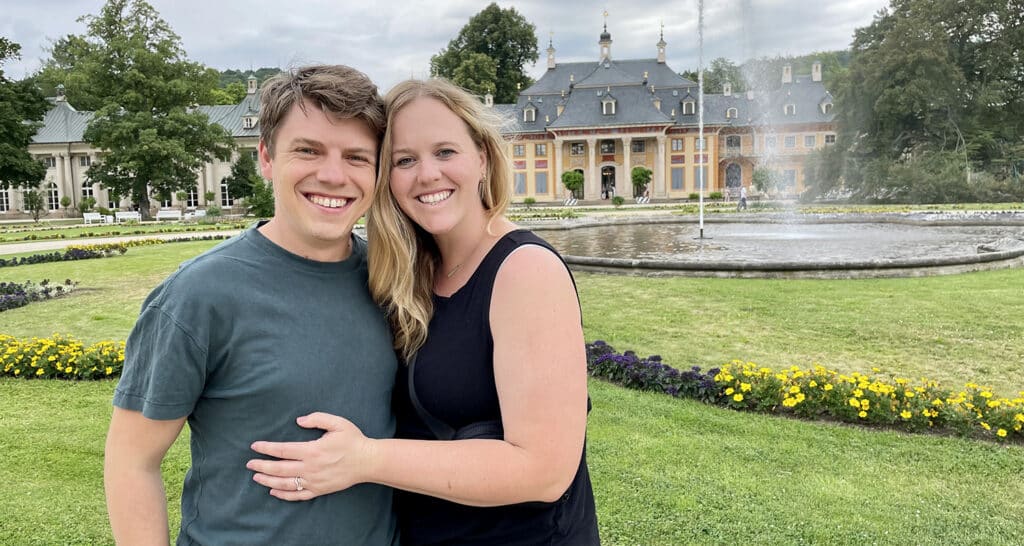 A man and woman posing in front of a fountain.