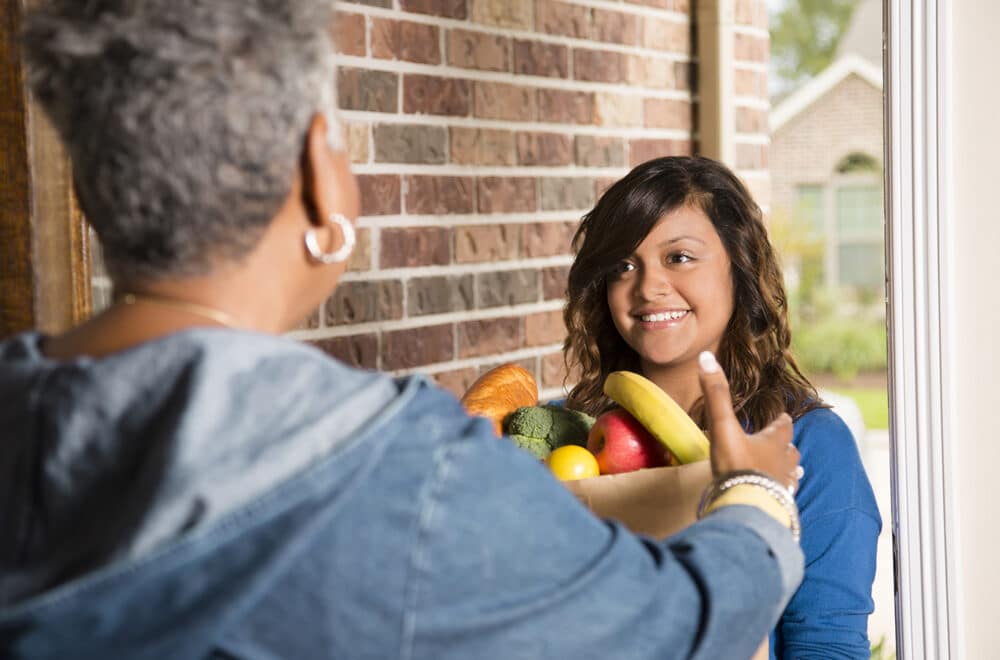 Kindness: Caring for One Another | Navigators Bible Study Resource | Volunteers: Young adult brings groceries to senior woman at home.