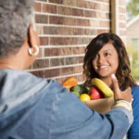 Kindness: Caring for One Another | Navigators Bible Study Resource | Volunteers: Young adult brings groceries to senior woman at home.