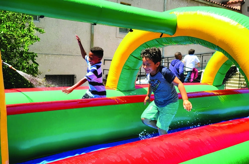 Children playing on inflatable course at Eagle Lake On Location summer camp.