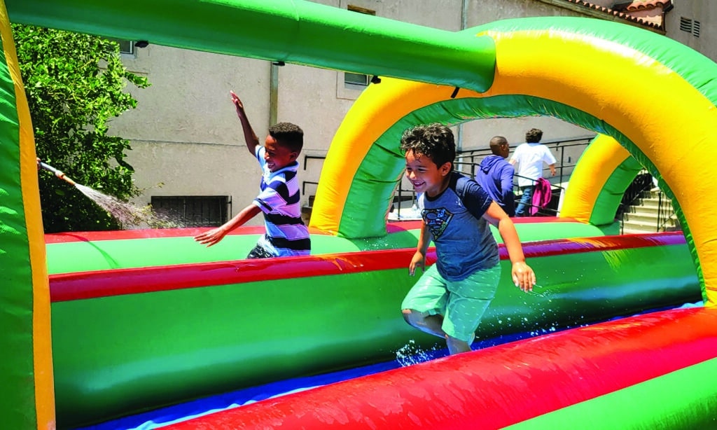 Children playing on inflatable course at Eagle Lake On Location summer camp.