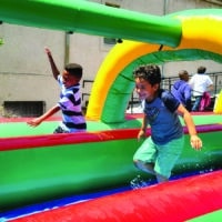 Children playing on inflatable course at Eagle Lake On Location summer camp.