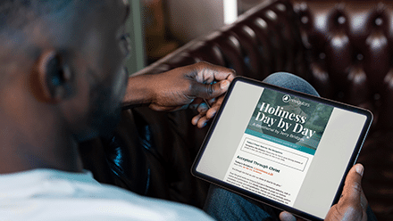Man reading the Holiness Day by Day devotional on an iPad