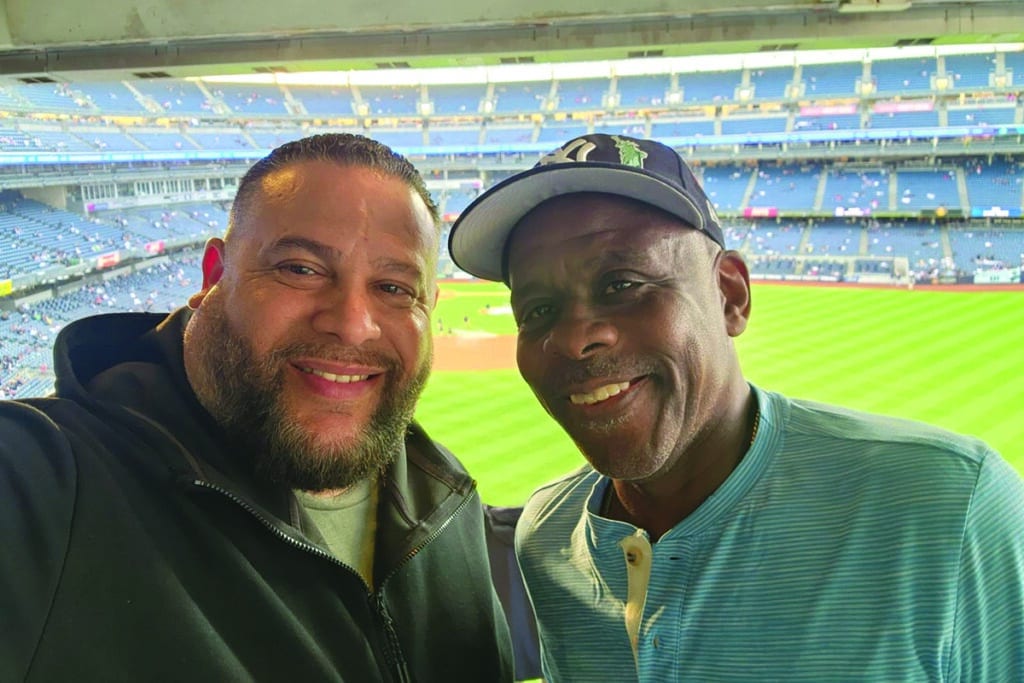 Two male co-workers enjoy a baseball game together.