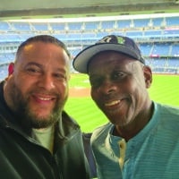 Two male co-workers enjoy a baseball game together.