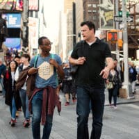 Two people walking and talking in the streets of NYC.