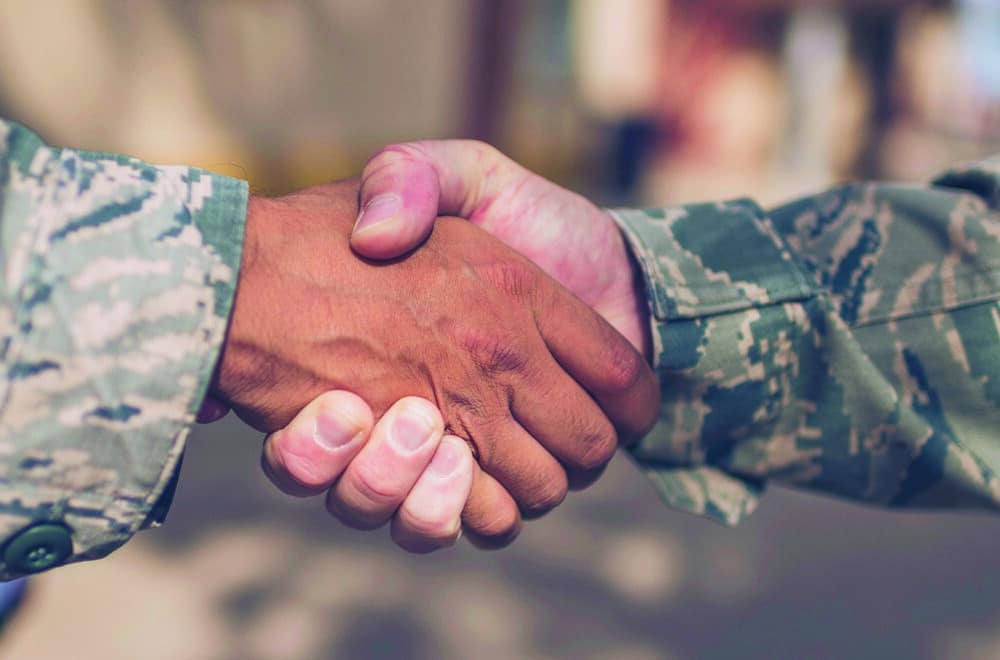 Two Male Soldiers in Military Uniform Shaking Hands