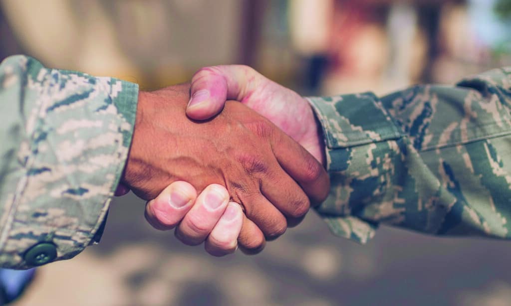 Two Male Soldiers in Military Uniform Shaking Hands