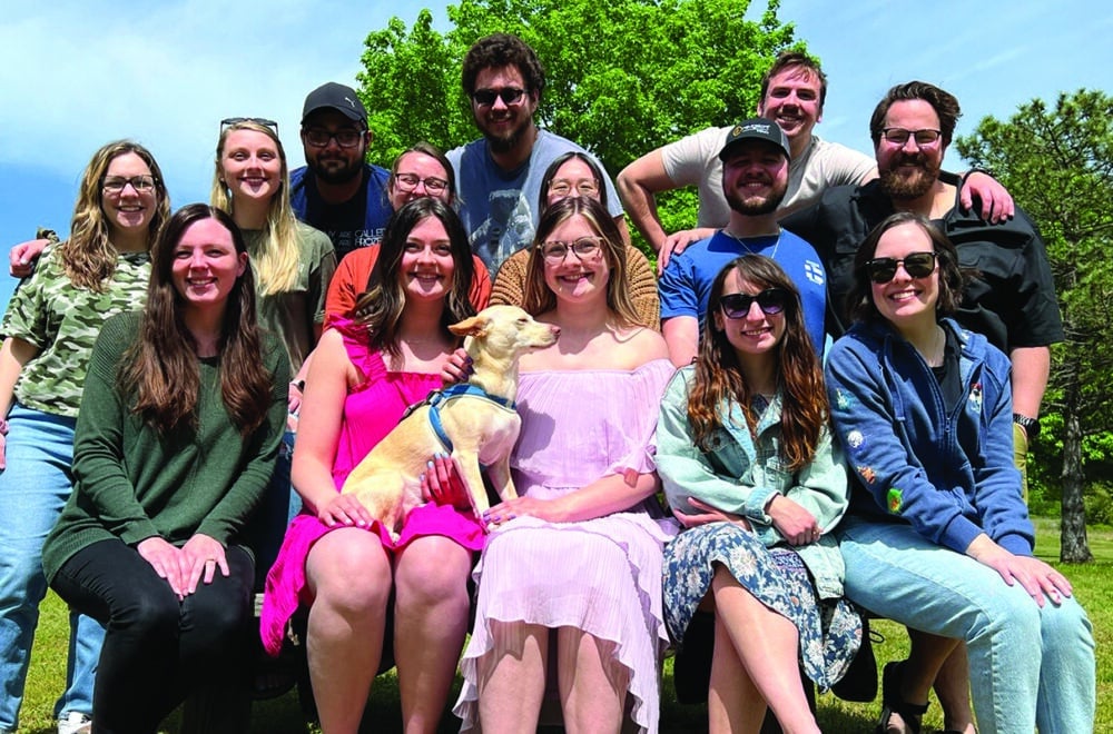 The Preckles, a Navigators family, stand next to the dozen young adults they are discipling at home.
