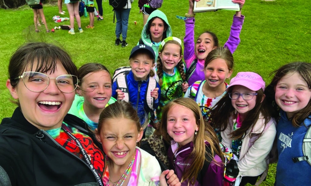 A group of kids from Eagle Lake Camp stand with their camp counselor.