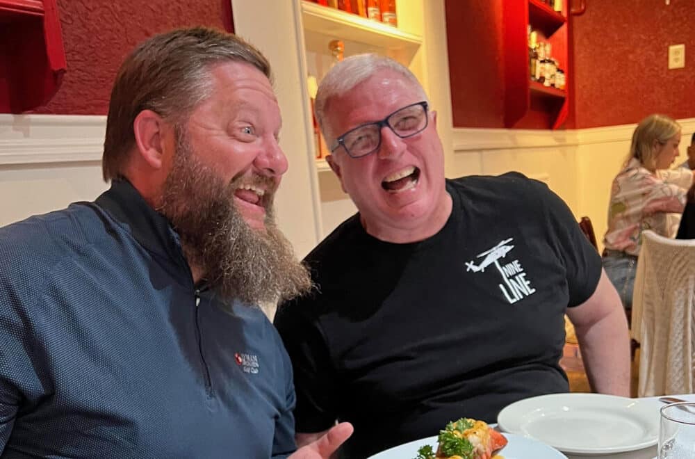Two men sitting in a restaurant laughing.