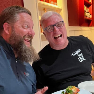 Two men sitting in a restaurant laughing.